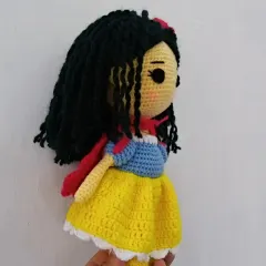 A side view of my handmade Snow White doll, showing the details of her classic dress with its blue bodice, yellow skirt, and red cape.