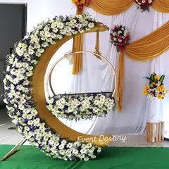 A close-up of my popular crescent-moon cradle design. I cover the entire structure with fresh white daisies and other flowers, making it a stunning centerpiece for any naming ceremony or baby shower.