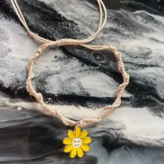 This simple, twisted macrame bracelet with a happy daisy charm is perfect for celebrating friendship.