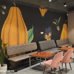 For this cafe, I designed a bold wall mural featuring cocoa pods and hummingbirds on a dark background. The vibrant, large-scale artwork creates a cozy yet striking ambiance that perfectly complements the cafe's theme.