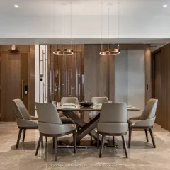 A thoughtfully curated dining area featuring a table with a unique cross-base design and elegant leather chairs. Wood-paneled walls and contemporary pendant lights add warmth and sophistication, creating an intimate atmosphere for meals.