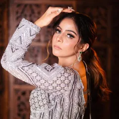 A close-up portrait showing how the outfit pairs with glamorous makeup. The emerald earrings add a beautiful pop of color.