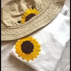 Wear your sunshine! A custom hand-embroidered bucket hat and matching t-shirt, both featuring a bright and cheerful sunflower design.