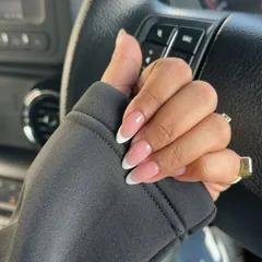 A casual shot of a perfectly executed French manicure on natural-looking oval nails, ideal for an everyday chic look.
