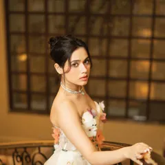 A side-profile portrait from the GlobalSpa editorial with Jannat Zubair. This shot captures a softer, more contemplative moment, highlighting the delicate details of the gown and diamond necklace.
