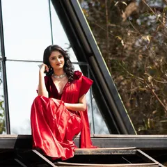 Juxtaposing the traditional red saree with modern architecture. This creates a visually interesting fusion of styles.