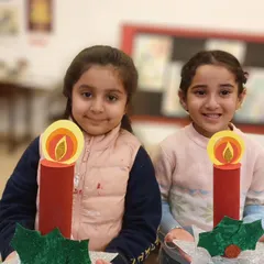 Two students proudly hold up their handmade Christmas candle crafts. These festive projects are a great way for our 5 to 7-year-olds to get into the holiday spirit.
