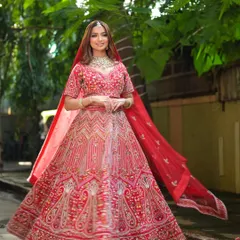 A full-length shot of a bride in a magnificent red lehenga, perfect for capturing those grand, cinematic wedding photos. My rental collection focuses on providing these unforgettable looks.