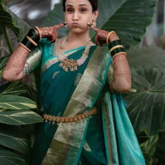 A bride's personality should always shine through. This playful shot captures her bubbly spirit, while also showing off the details of her Maharashtrian engagement look, including the classic green glass bangles and gold kamarbandh.
