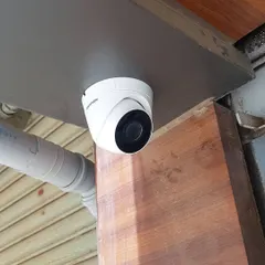 A Hikvision dome camera installed under an overhang. This type of camera is less obtrusive and provides a wide field of view for areas like patios and entryways.