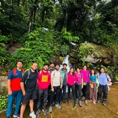 The group takes a break at a small, serene waterfall during the Tadiandamol trek.
