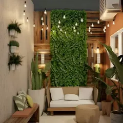 A cozy balcony nook designed for evening relaxation. This space features a vertical garden, a small sofa, and a string of Edison bulbs that create a warm and magical ambiance.