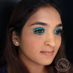 This angle highlights the complete eye makeup, including the voluminous false lashes on the top lash line. Paired with a soft, neutral lip, the focus remains entirely on the dramatic, retro eyes.