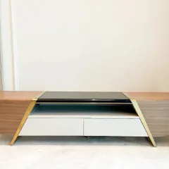 This custom console table features American walnut veneer expertly bent around a curved frame. The design is accented with brushed PVD gold details and a central black glass top, creating a sophisticated piece that balances natural wood grain with polished modernity.