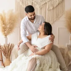 An intimate moment between expecting parents in our cozy boho-themed studio corner. The natural tones and textures create a warm and relaxed setting for couple maternity portraits.