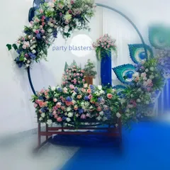 A closer look at the cradle area for a Krishna-themed naming ceremony. The circular arch is heavily decorated with a mix of pink, blue, and white flowers, creating a lush and beautiful frame for the baby's cradle.