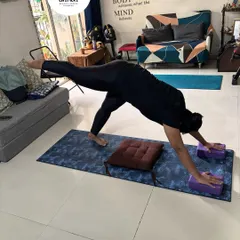 This client is in a three-legged downward dog pose, using blocks under her hands for better alignment and wrist comfort. This pose strengthens the arms and shoulders while stretching the entire back of the body.
