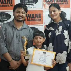 A student, his parent, and his teacher pose together with his award. This highlights the triangle of support between student, family, and our institute that fosters growth.