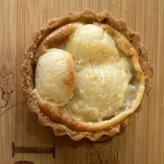 A close-up of my baked rasgulla tart. This is a unique fusion dessert, where the soft, syrupy rasgulla is baked into a creamy filling inside a crisp tart shell.