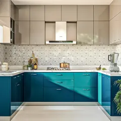 A vibrant and contemporary U-shaped modular kitchen. The dual-tone design pairs glossy teal base cabinets with sleek grey overhead units, complemented by a striking geometric backsplash tile and a clean white countertop, making it a perfect example of modern kitchen interiors.
