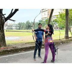 I work closely with each student to perfect their form. Here, I'm guiding an archer on her posture and aiming technique with a recurve bow, a crucial step in building muscle memory for consistent shots.