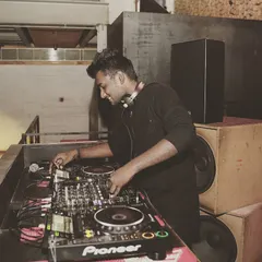 A candid shot of me smiling while I mix. I genuinely love what I do, and that passion comes through in every set I play.