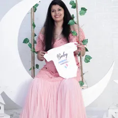 A sweet and simple announcement. The mom-to-be holds up a "Baby Loading" onesie while sitting on our dreamy moon swing prop, a perfect way to share the news.