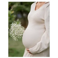 A close-up of the baby bump, framed by a delicate bouquet of baby's breath. This is an elegant and classic maternity shot that focuses on the new life you're carrying.