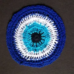 An evil eye themed 6-inch crochet doily. A perfect matching piece to go with my keychains for a themed gift set.