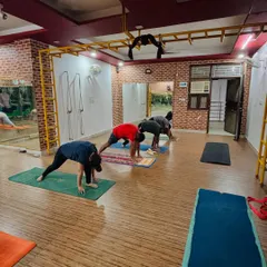 A group of students practicing Ashwa Sanchalanasana (Equestrian Pose) as part of a vinyasa flow in our Dwarka studio.