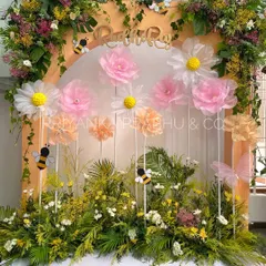 The full backdrop for Rudhi's garden-themed second birthday party. We combined fresh greenery, real flowers, and oversized fabric daisies to create a playful and enchanting photo corner.