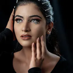 A dreamy and artistic shot of this high-fashion look. The model's gaze and the unique makeup come together to create a captivating and memorable image.