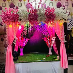 Here is another angle of the pink floral mandap, showing how it looks in a home setting. The grass base and elegant vases complete this ready-to-use decoration for a hassle-free celebration.