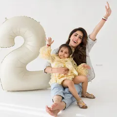 Pure joy and celebration! A mother and daughter wave happily during a fun and energetic second birthday photo session.