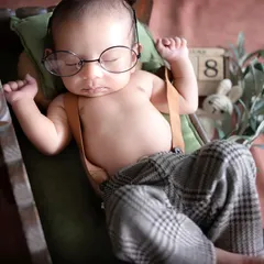 A close-up of our dapper little man, sleeping soundly with his tiny glasses. Every detail, from his suspenders to his relaxed hands, is just perfect.