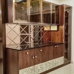 A luxurious crockery unit design featuring dark wood, a diamond-patterned mirror backsplash, and glass-front cabinets. This piece adds both storage and glamour to a dining area.