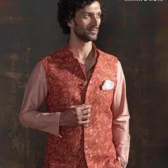 This terracotta embroidered Nehru jacket, layered over a blush-toned kurta set, is a poetic blend of tradition and tailored modernity. The all-over floral threadwork in earthy tones is perfect for the man who doesn’t just wear tradition, he redefines it.