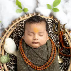 A 'Har Har Mahadev' themed shoot for this little one. I use soft wraps, a rudraksha mala, and iconic props like the trishul and damaru to create a divine and safe setting, perfect for capturing these blessed early days.