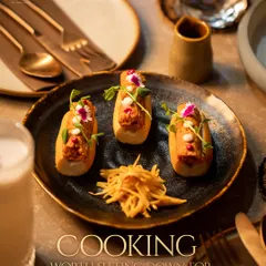 An appetizer designed for slow enjoyment. These small bites feature a savory filling on a soft bread base, garnished with microgreens and edible flowers. Each element is placed with care.