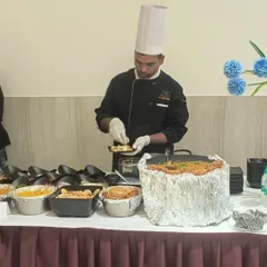Our chef is carefully preparing a dish at a live chaat counter. These interactive stations are a fantastic way to engage guests and offer them customized, freshly made snacks.