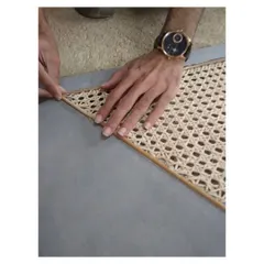 The process of hand-weaving cane into a custom cabinet shutter. I value traditional craftsmanship and often collaborate with skilled artisans to create bespoke details that bring a natural, retro feel to my interiors.