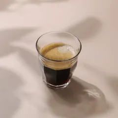 A minimalist shot of an espresso, created for a Bangalore-based coffee brand. This image is clean and modern, focusing on the beautiful crema and shadows.