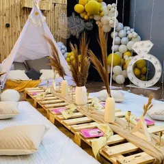 This close-up highlights the details of our popular boho-chic bachelorette party theme. We use natural textures like wooden pallets for seating, pampas grass in ceramic vases, and fun props like a diamond ring marquee light to create a trendy, relaxed vibe.