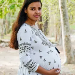 A lovely portrait of an expectant mother in a white dress, enjoying a moment in the park. We use natural settings to create a relaxed and beautiful backdrop.