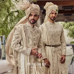 Another view of the groom and his groomsman. The subtle variations in embroidery and accessories ensure each man has his own distinct look while maintaining a cohesive aesthetic.