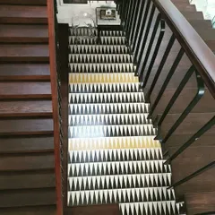 On this staircase, we used a bold triangular tile pattern to break the simplicity of the wood and add character. The geometric design in black, white, and gold creates a stunning visual effect, turning the staircase into a feature element of the home.