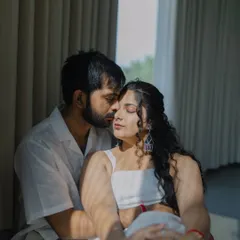 An intimate pre-wedding portrait, with soft light filtering through the curtains. This frame captures a tender kiss on the forehead, a silent promise of care and affection.