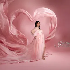 Using the flowing fabric of the gown, I can create beautiful shapes and silhouettes. Here, the long train of a pink dress forms a perfect heart around the expecting mother.