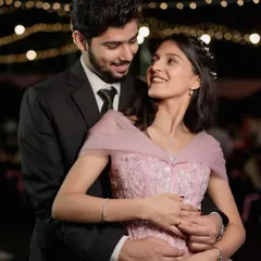 A happy and natural portrait of a newly engaged couple. Her pink gown and his classic suit make for a modern and elegant look.