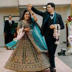 A candid, action-filled shot of the couple's entrance. The groom giving his bride a twirl shows their fun-loving personalities and the celebratory mood.